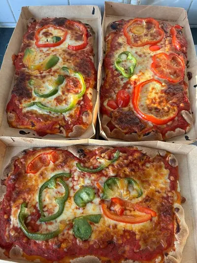 Parts de pizza maison aux poivrons cuites pour la distribution